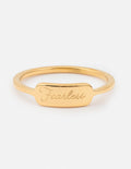 Gold ring with 'Fearless' engraving on a white background