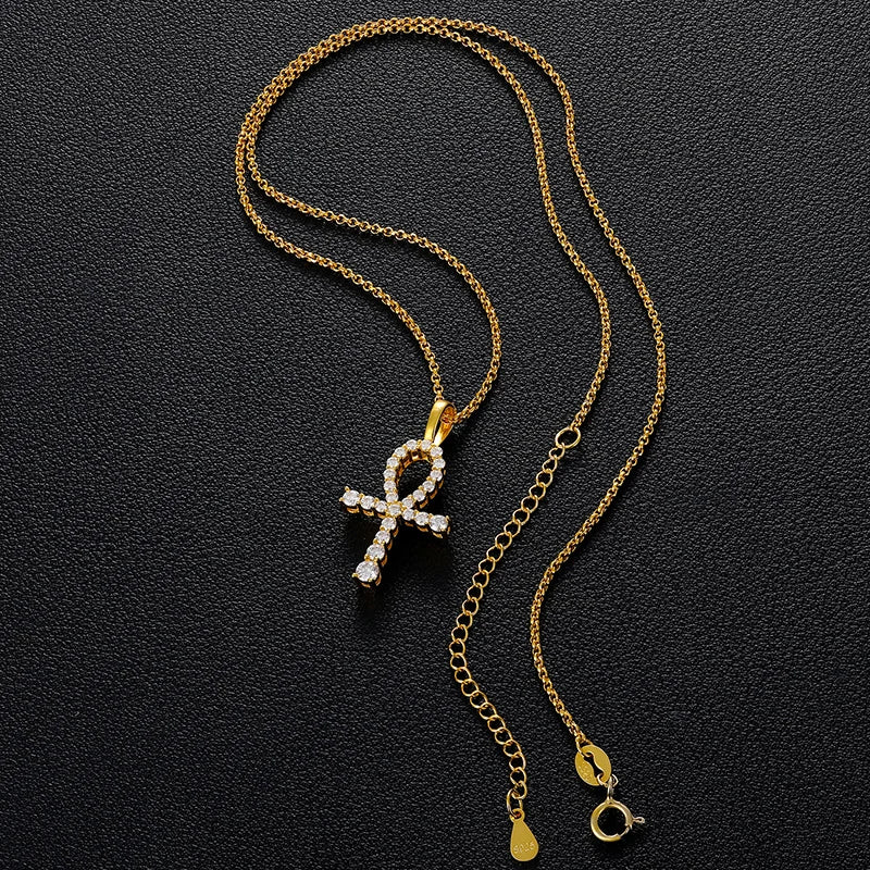 Gold necklace with a cross-shaped pendant on a black background