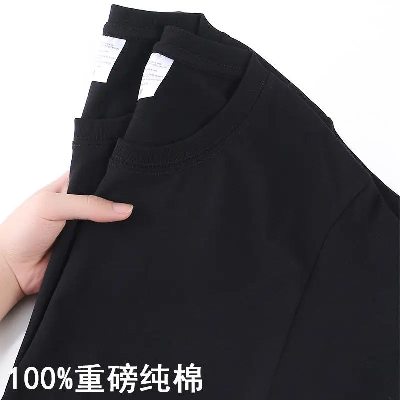 Black shirt with a hand holding it, showing a label and text on a white background