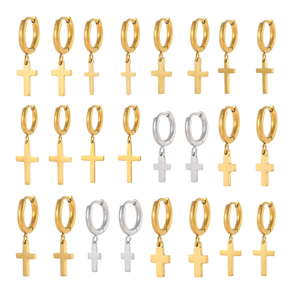 Set of gold and silver hoop earrings with cross pendants on a white background