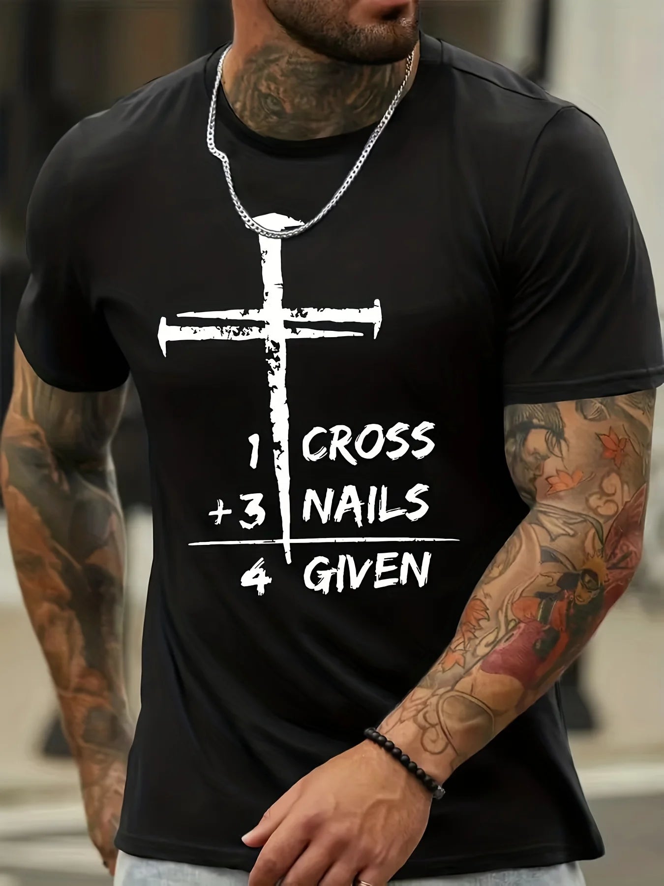 Person wearing a black t-shirt with a white cross design and text.