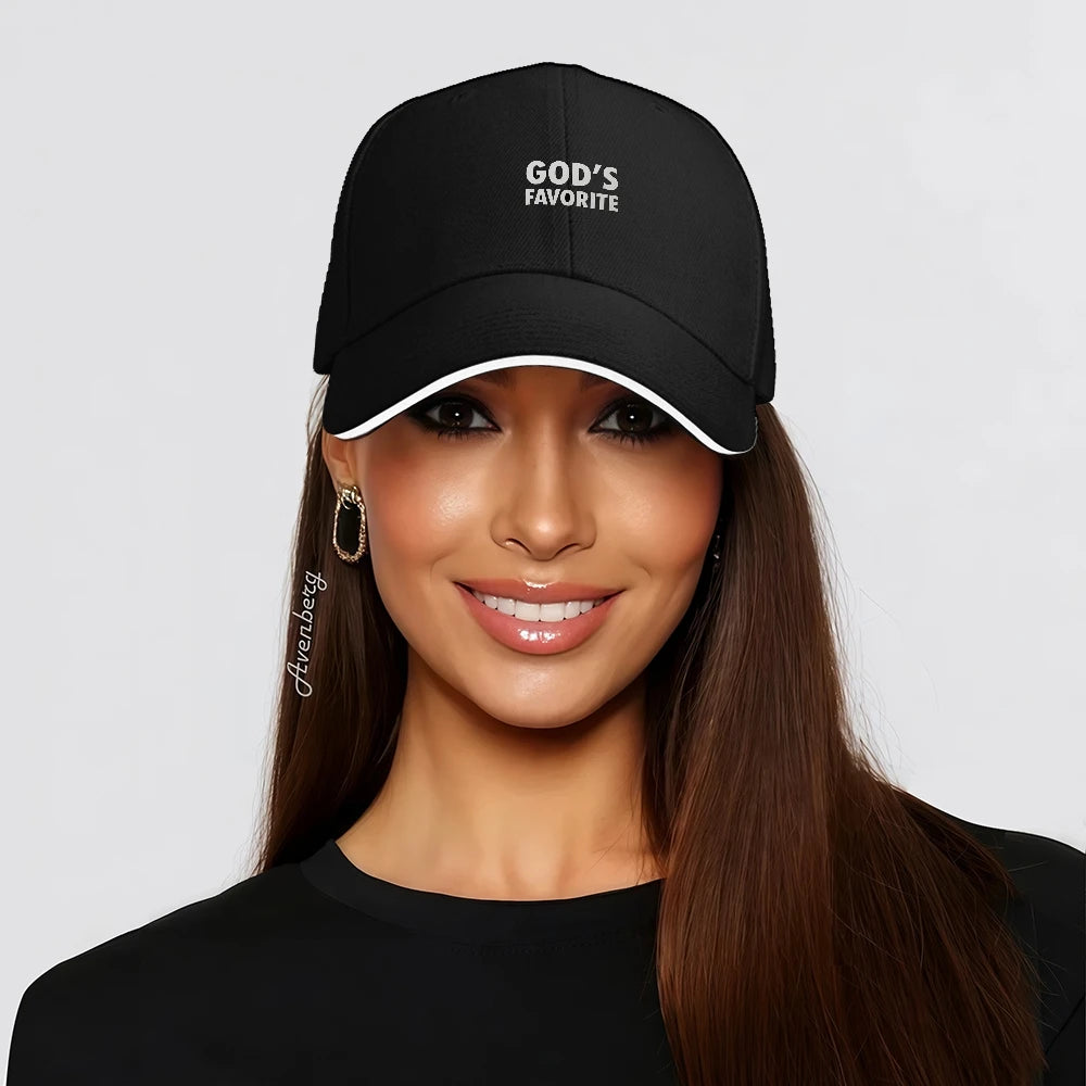 Woman wearing a black cap with 'God's Favorite' on a light gray background