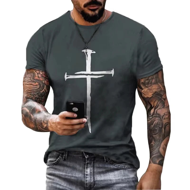 Man wearing a dark gray t-shirt with a white cross design, holding a phone.