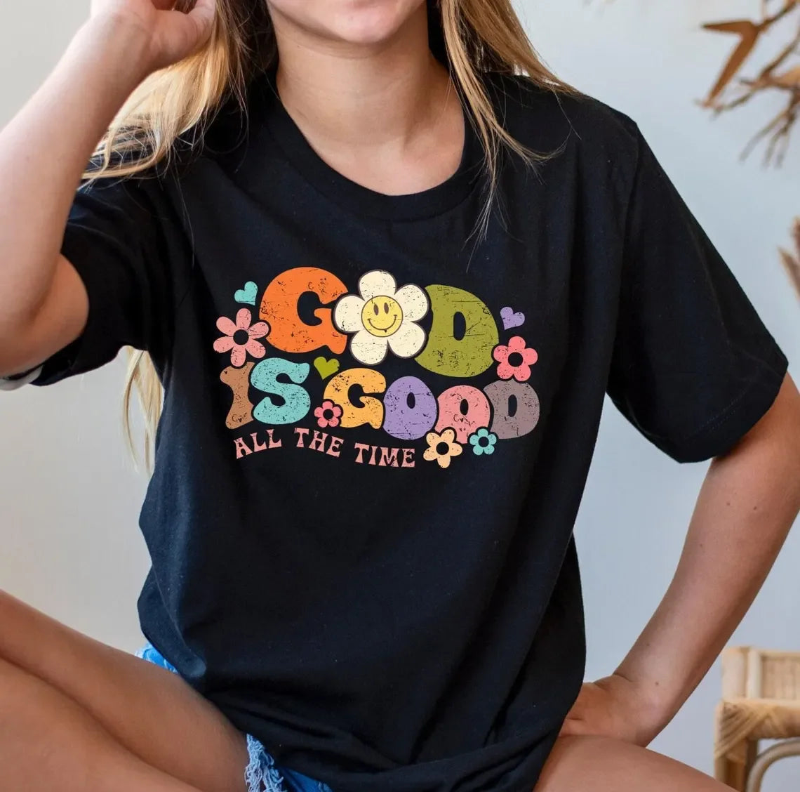 Person wearing a black t-shirt with colorful text and graphics.