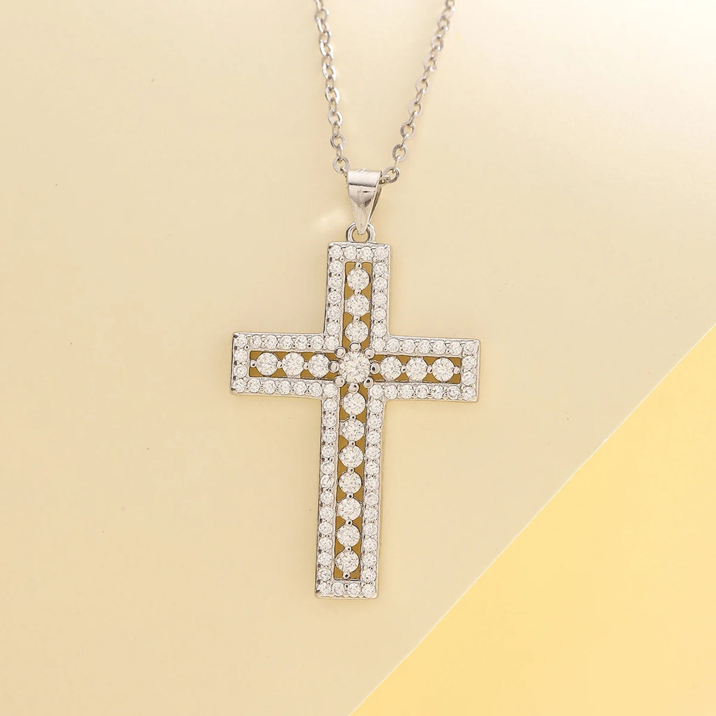 Diamond-studded cross pendant on a chain against a beige background