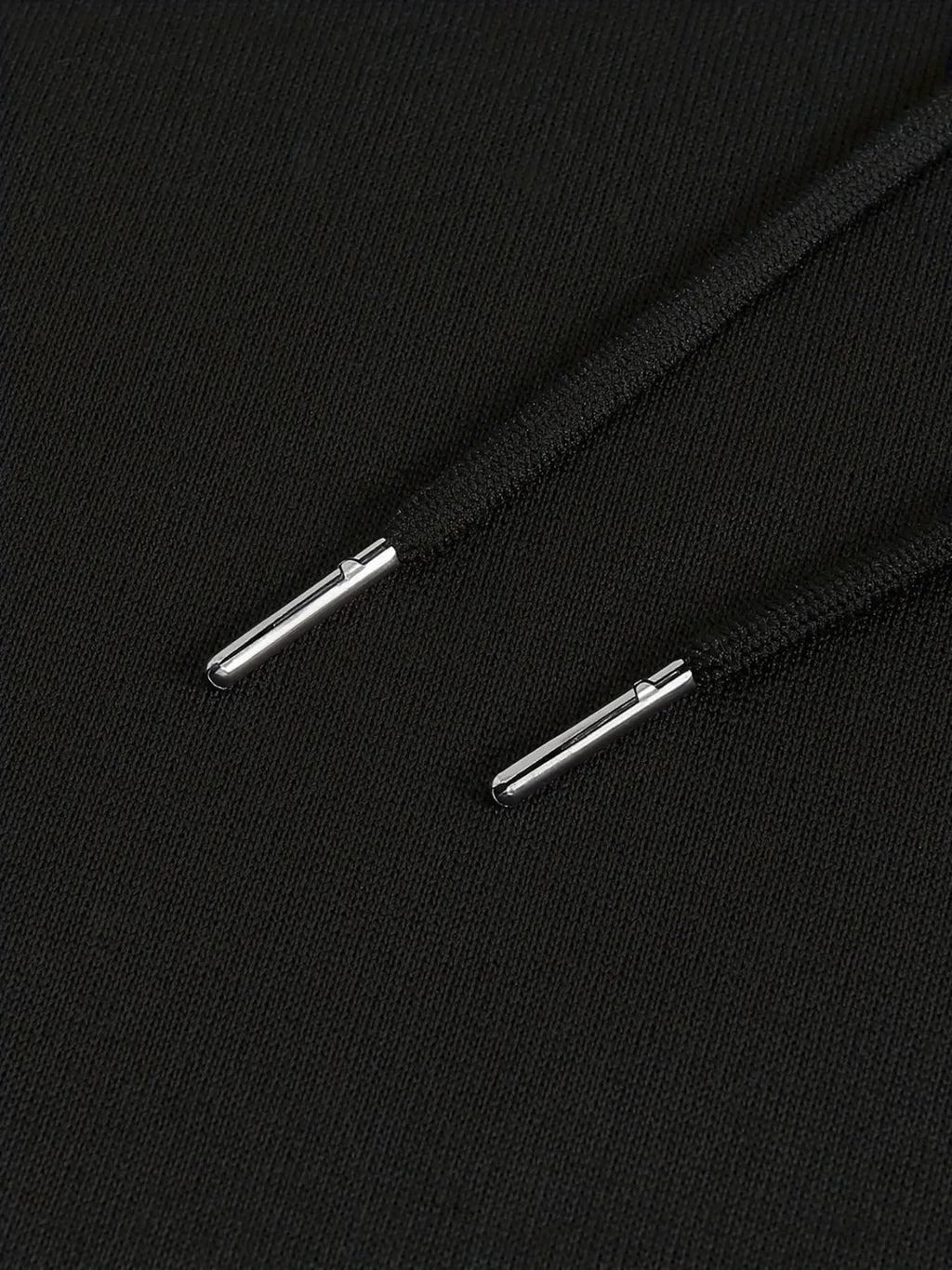 Close-up of black shoelaces with metal eyelets on a black background