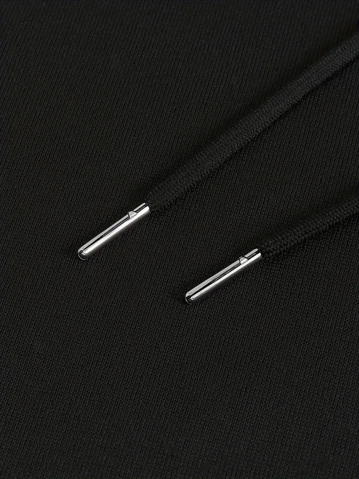 Close-up of black shoelaces with metal eyelets on a black background