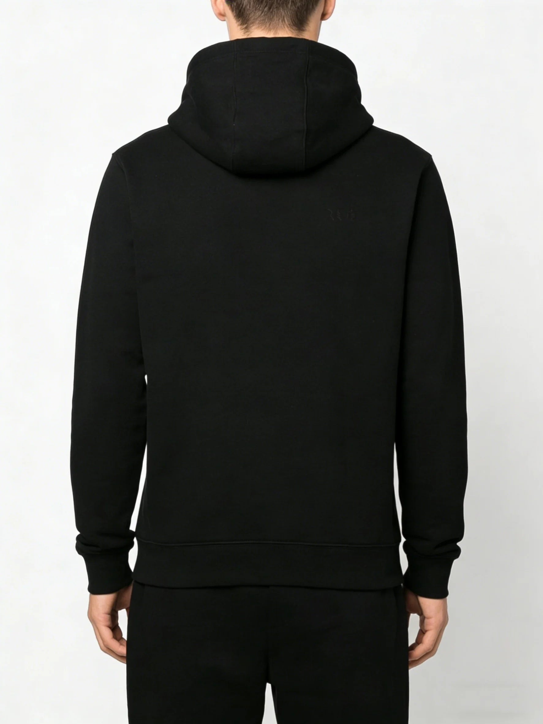 Black hoodie worn by a person on a light gray background