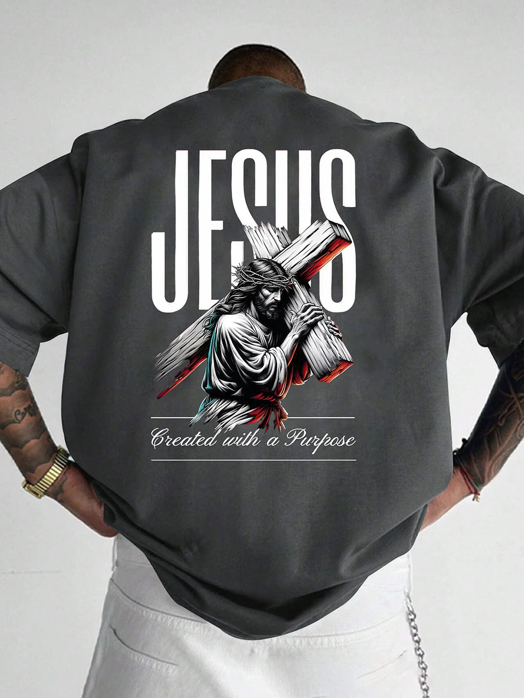 Person wearing a dark gray shirt with a graphic of Jesus carrying a cross and text on the back.