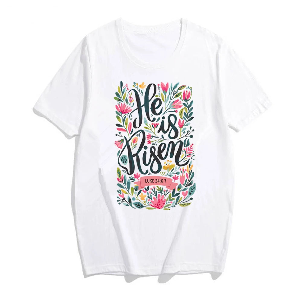 White t-shirt with 'He is Risen' text and floral design on a white background