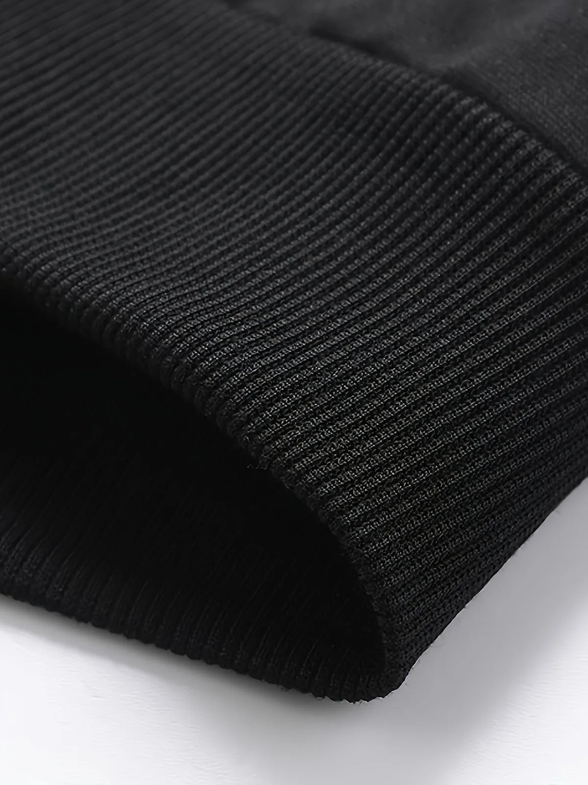Close-up of a black ribbed knit fabric on a white background