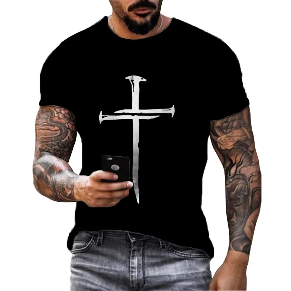 Man wearing a black t-shirt with a silver cross design, holding a phone.