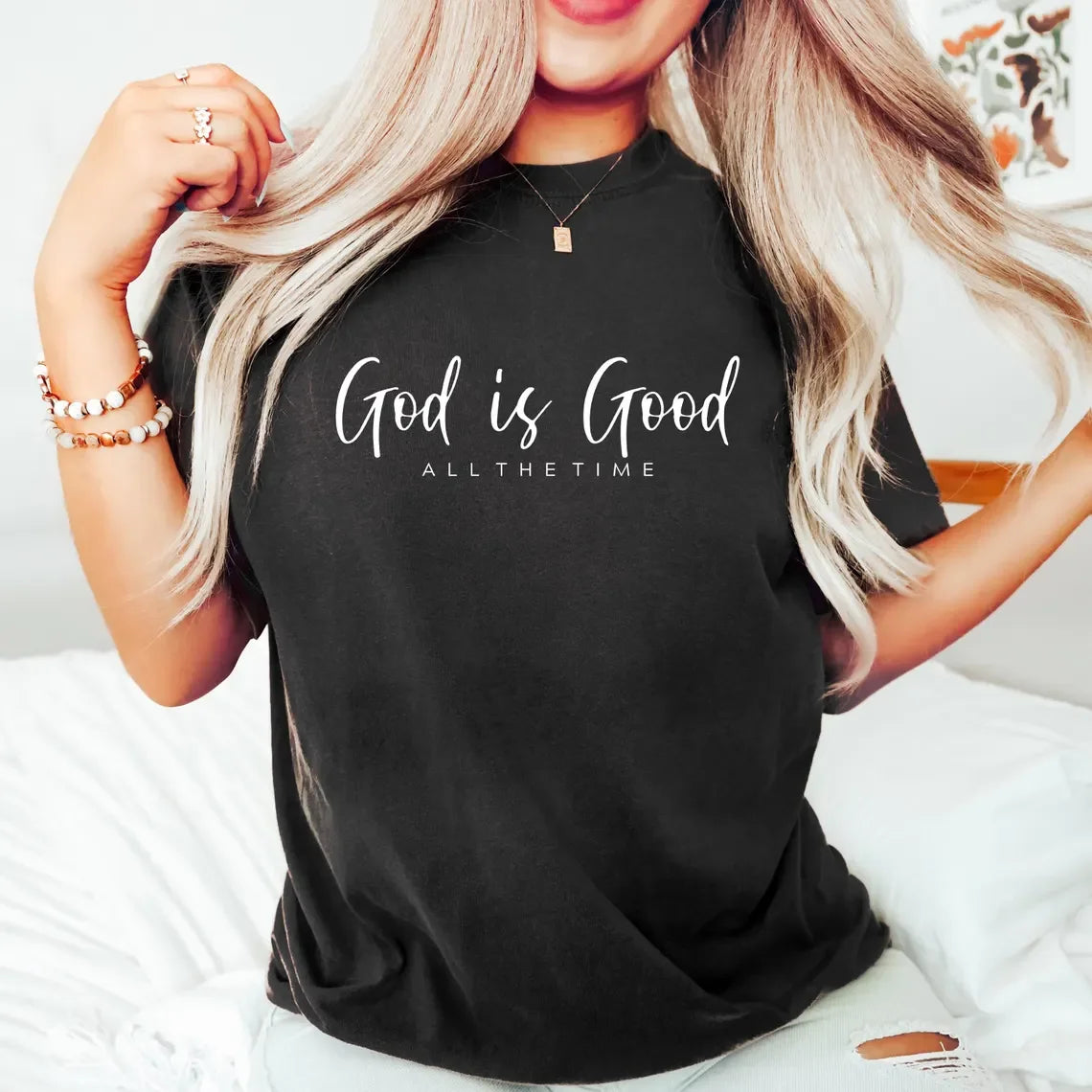 Person wearing a black t-shirt with 'God is Good All the Time' text.