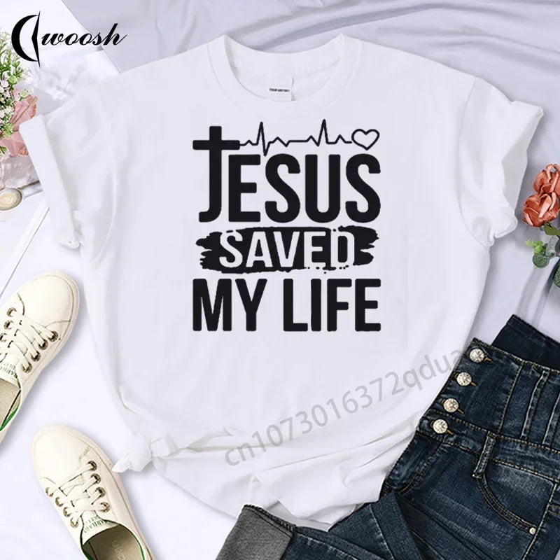 White t-shirt with 'Jesus Saved My Life' text on a white background with shoes and jeans.