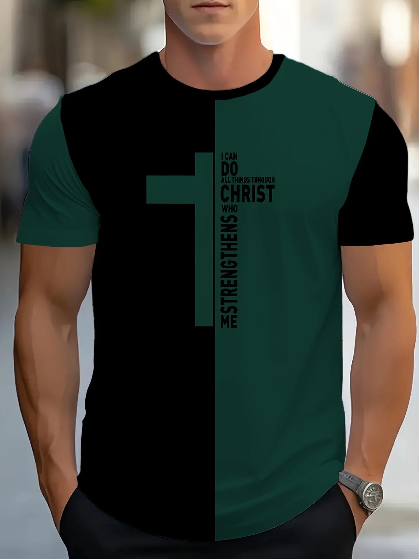 Person wearing a black and green t-shirt with a cross design and text.