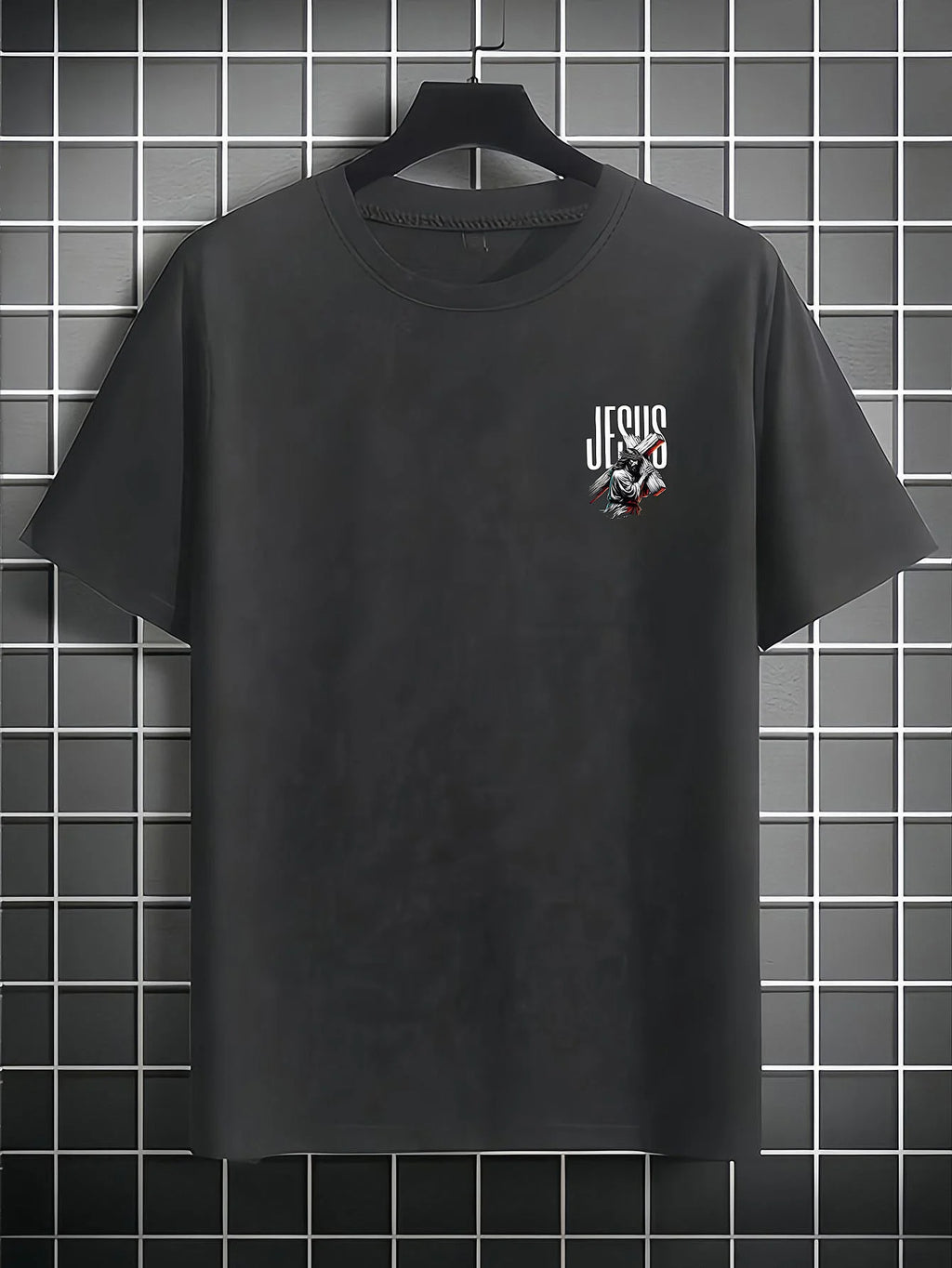 Black t-shirt with 'Jesus' graphic on a hanger against a tiled wall.