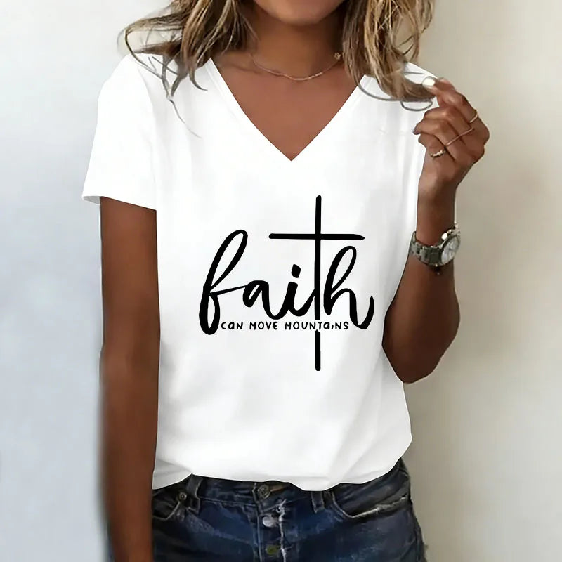 Person wearing a white t-shirt with 'faith can move mountains' text