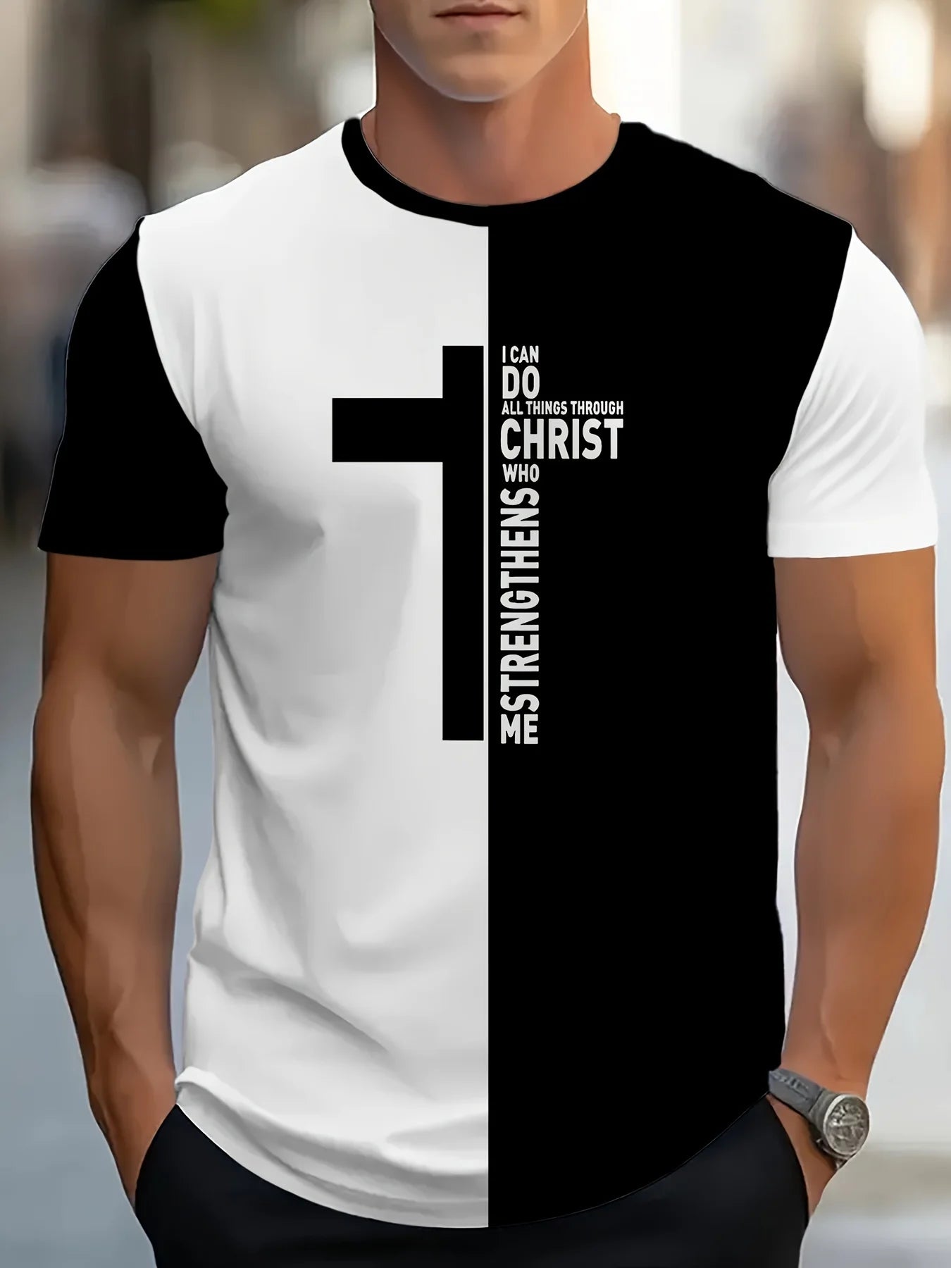 Person wearing a black and white t-shirt with a cross design and text.