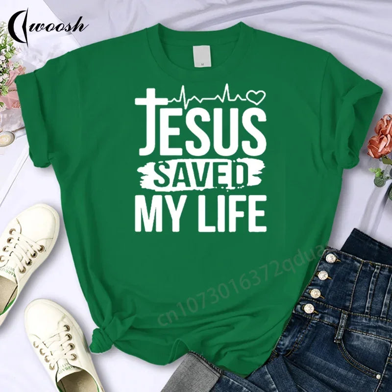 Green t-shirt with 'Jesus Saved My Life' text on a white background with shoes and jeans.